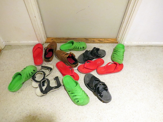 Mustia, punaisia ja vihreitä kenkiä lattialla. 