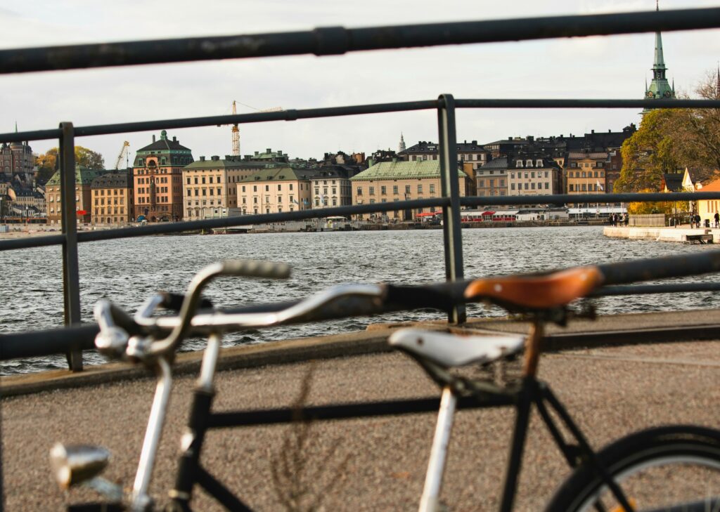 Etualalla kaksi polkupyörää, taka-alalla vettä ja kaupunkisiluettia.